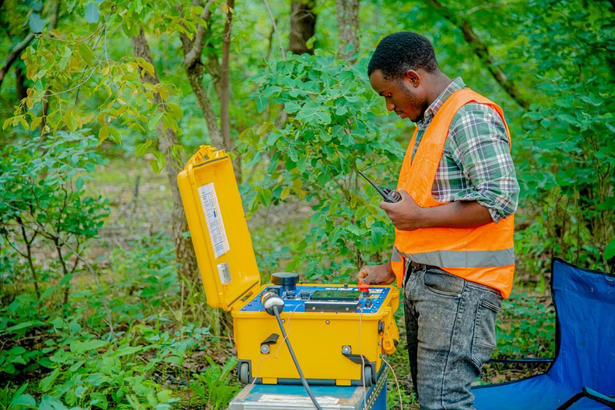 Geophysicist operating a transmitter unit during a field survey